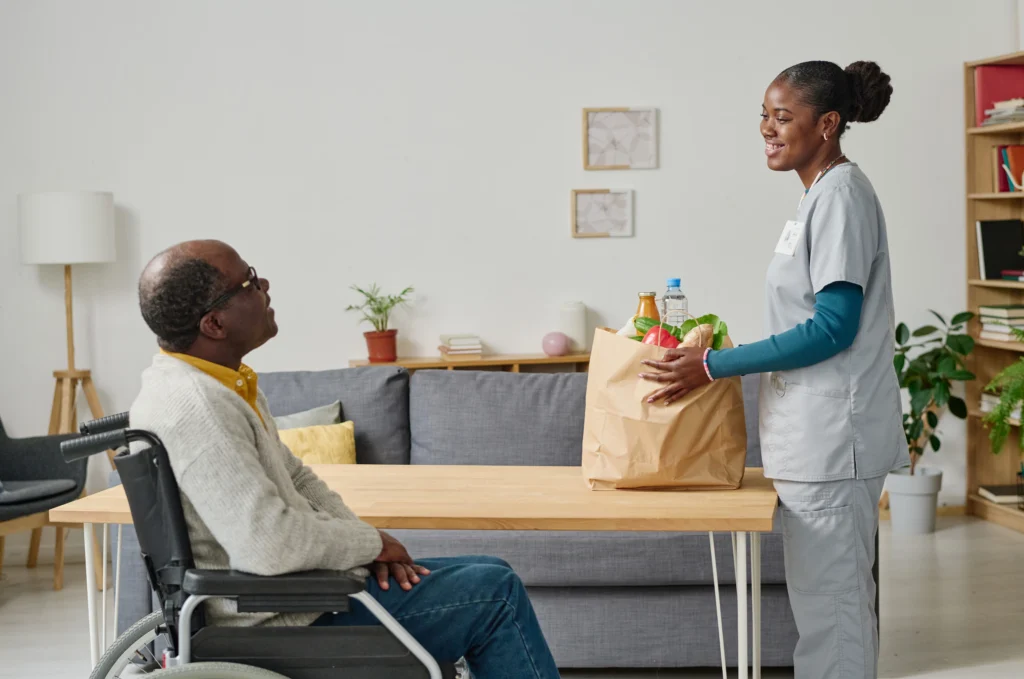 Carer providing meal preparation support for an older adult at home